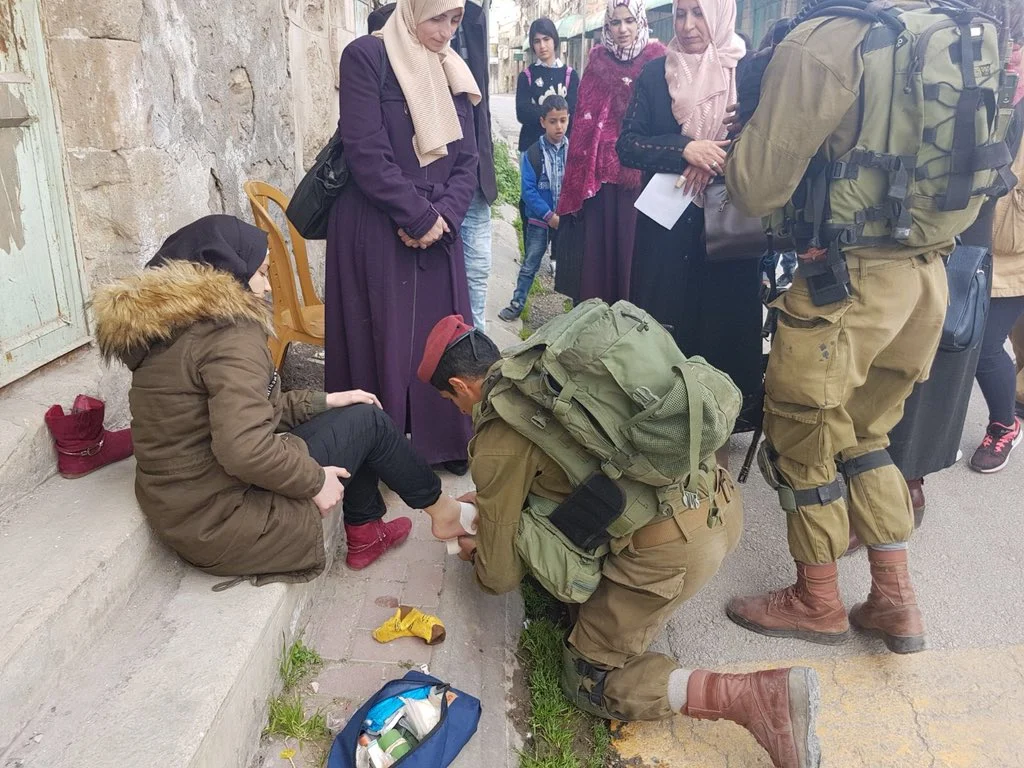 Kriegsführung in Israel: Ein israelischer Soldat hilft einer verletzten Palästinenserin